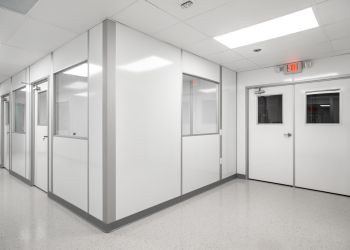 Interior view of a class 100 modular cleanroom corridor built by Allied Cleanrooms, featuring white wall panels and integrated windows.