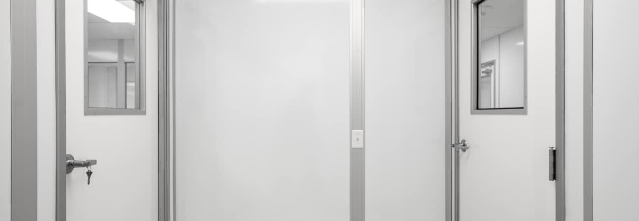 Modular cleanroom interior with pre-engineered wall panels and framed doors, built by Allied Cleanrooms for controlled manufacturing environments.