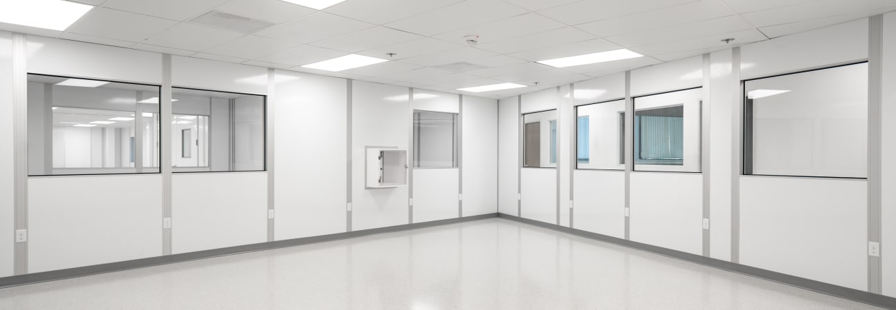 Modular white room with bright LED lighting, clean panel walls, and integrated viewing windows, built by Allied Cleanrooms.