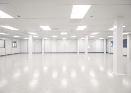A spacious, brightly lit cleanroom featuring smooth, seamless cleanroom flooring and white walls.