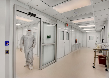 Person in full cleanroom gown exiting modular class 100 cleanrooms built by Allied Cleanrooms.