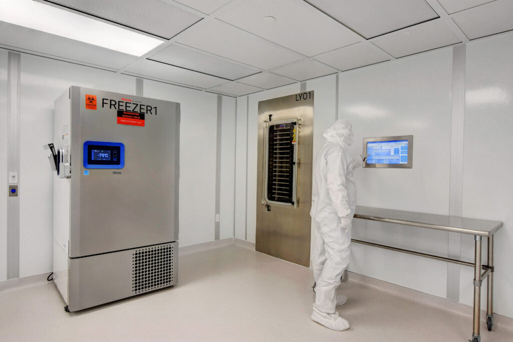A cleanroom worker observes a monitoring system.