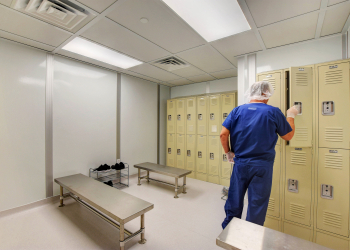 Cleanroom technician preparing in a gowning room following cleanroom gowning procedures at Allied Cleanrooms