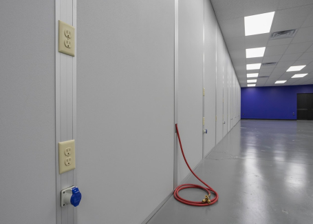 Post-and-panel cleanroom walls with integrated electrical outlets and utility connections in a controlled environment by allied cleanrooms modular cleanroom design