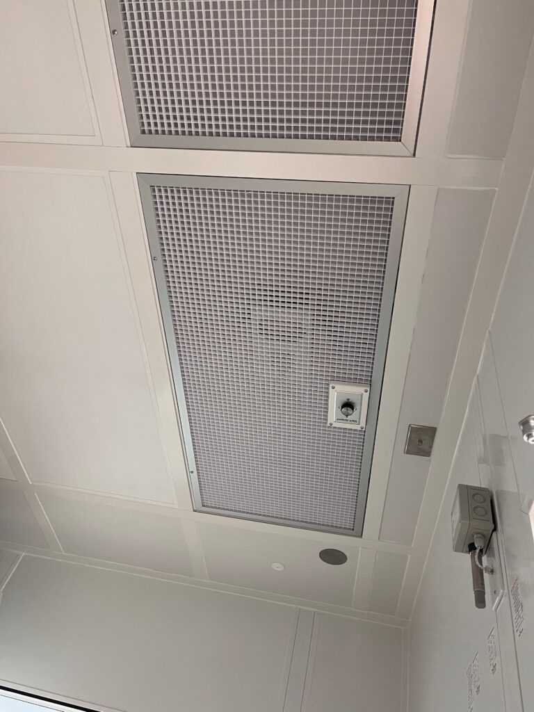 Cleanroom ceiling with gridded panels housing HEPA filters as part of a Fan Filter Unit (FFU) system.