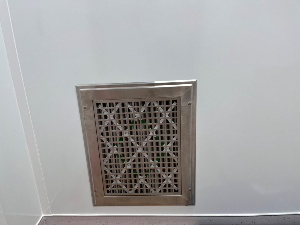 An air return grille in the lower wall of a cleanroom.