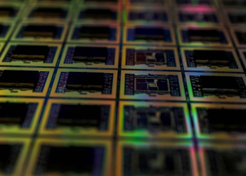 Close-up of semiconductor wafers manufactured in semiconductor cleanrooms with intricate circuit patterns.