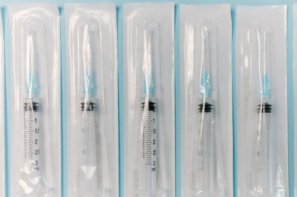 Five individually packaged sterile syringes arranged in a row.