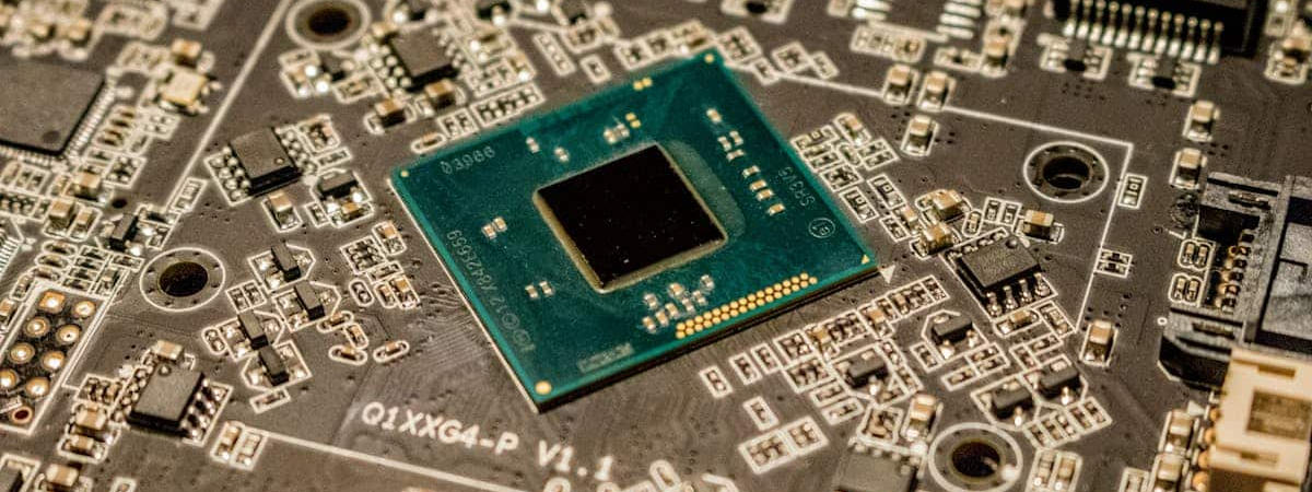 Close-up of a microchip on a circuit board with various electronic components.