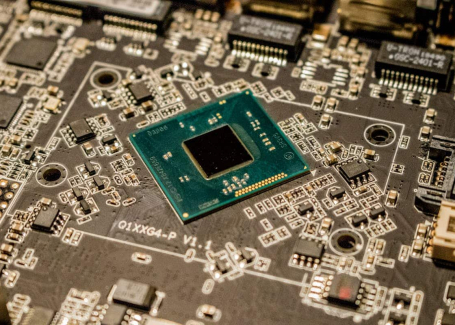 Close-up of a microchip on a circuit board with various electronic components.