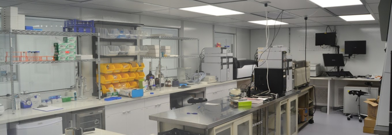 A clean, organized laboratory with workstations, lab equipment, and storage shelves, used for scientific research or testing. Allied Cleanrooms