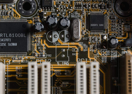 Close-up view of an electronic circuit board showcasing intricate components and connections, highlighting the precision and cleanliness required in electronics manufacturing.