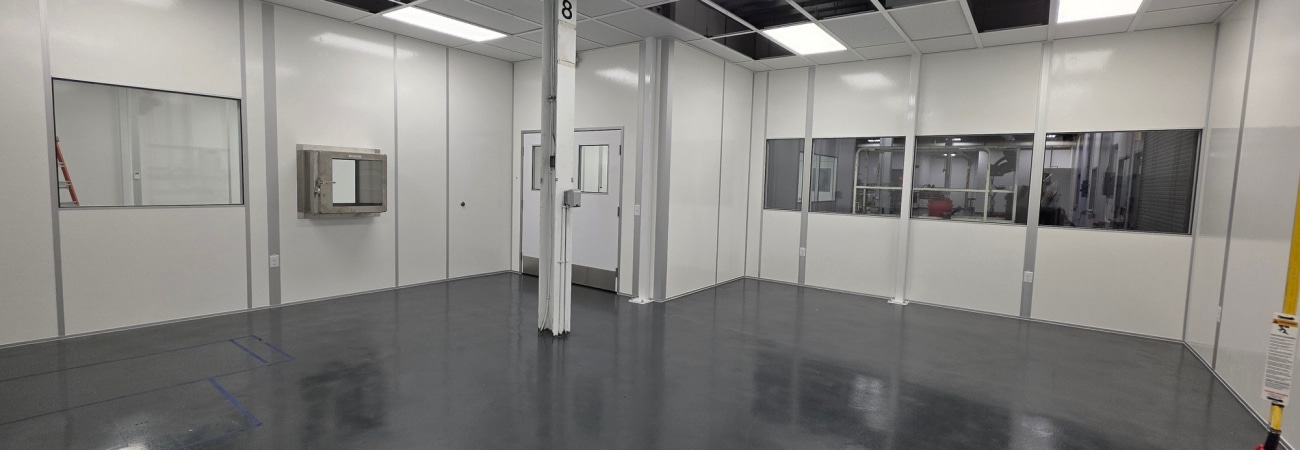 Modular cleanroom (designed via a cleanroom URS) interior by Allied Cleanrooms with pass-through chamber and wall windows.