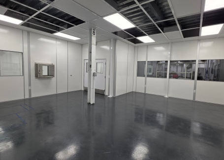 Modular cleanroom (designed via a cleanroom URS) interior by Allied Cleanrooms with pass-through chamber and wall windows.