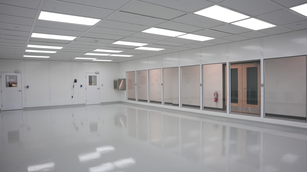 Spacious modular cleanroom with white wall panels, large viewing windows, and overhead lighting, built by Allied Cleanrooms.