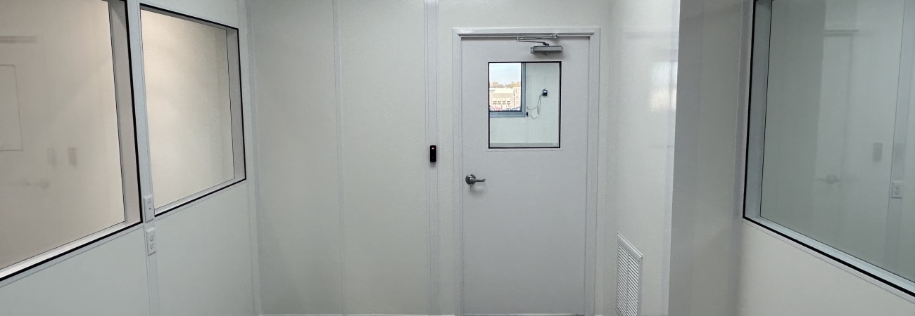 Interior of temperature-controlled rooms by Allied Cleanrooms, showing modular insulated walls, a sealed door, and cleanroom windows.
