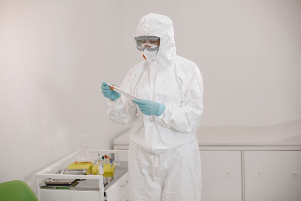 Technician in full protective suit performing cleanroom testing at an Allied Cleanrooms facility.