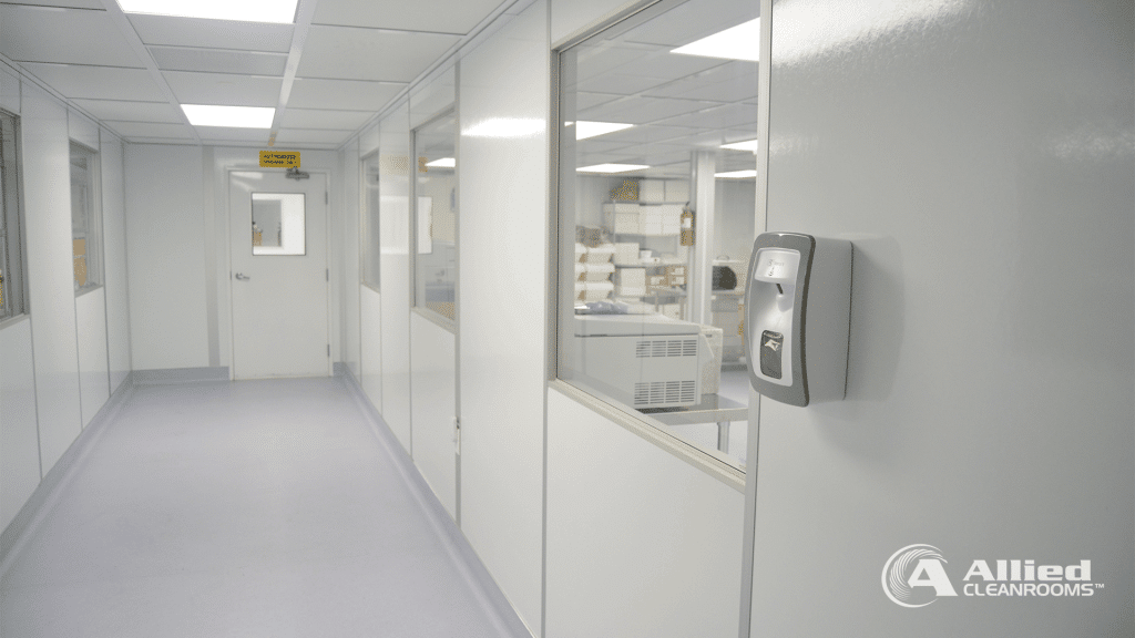 Post-Build Cleanroom Planning: What to Know Early On Interior hallway of a modular cleanroom built by Allied Cleanrooms, featuring flush wall panels, interior windows, and a wall-mounted sanitizer dispenser.