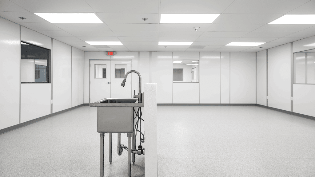 Interior of an Allied Cleanrooms cleanroom with sealed wall panels, double doors, and windows into adjacent rooms for cleanroom pressure cascade airflow control