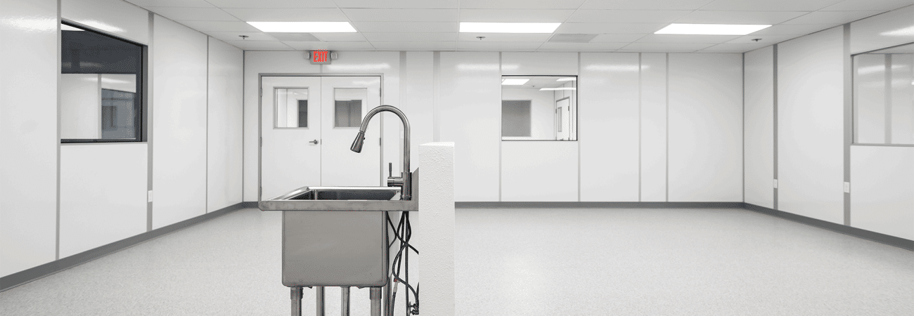 Interior of an Allied Cleanrooms cleanroom with sealed wall panels, double doors, and windows into adjacent rooms for cleanroom pressure cascade airflow control